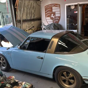 Classic blue Porsche Targa undergoing garage maintenance
