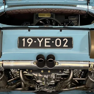 Classic Porsche 911 Targa rear view with open engine bay and polished twin exhausts.