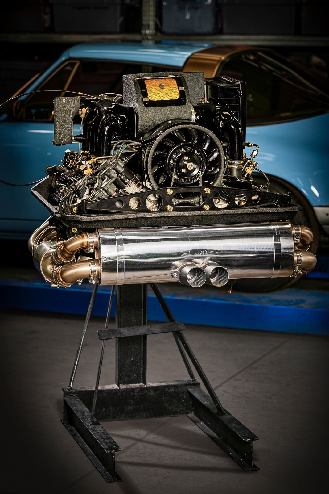 Restored car engine on stand, vintage vehicle background.